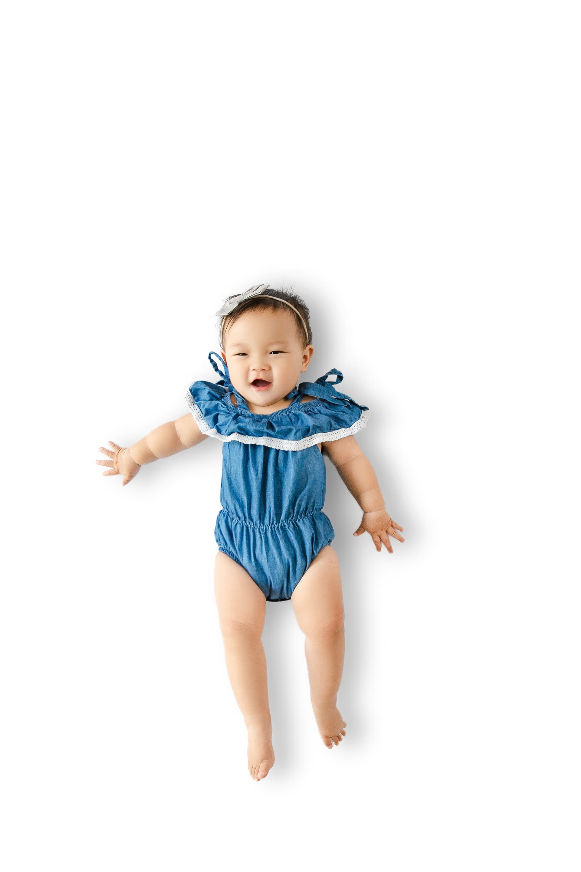 Baby sitting up on Everline mat surrounded by wooden toys
